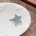 Detailed macro view of a silver Y2K star hair clip with blue rhinestones on a ceramic dish - Full Zirconia Pentagram / Green