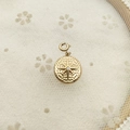 Golden round pendant with an embossed starburst and white stone on white floral lace - Octagram Zircon Gold Medallion