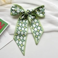 Green diamond lattice hair scarf with yellow hearts tied in a bow on textured fabric - Green Heart Argyle