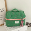 Detail of green quilted makeup bag with pink bow pattern and woven zipper puller - Green Fruit Bow [Makeup Bag]