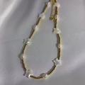 Goldene Sternen-Halskette mit weißen Perlen und Perlen auf weißem Satinhintergrund - 6# (Goldstern-Muschel-Halskette)