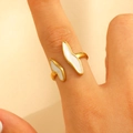 Gros plan sur la bague ajustable dorée avec motif en émail blanc en forme d'aile - Style Profilé Irrégulier Blanc (1345)