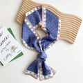 Navy blue skinny silk scarf with retro letter print and pink borders tied on a wooden board - D-Pattern Framed Blue