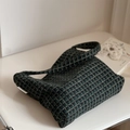 Gros plan d'un sac à bandoulière en laine à carreaux vert foncé avec étiquette tissée - Petit carreau vert foncé