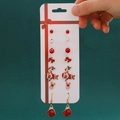 7-piece Christmas earring set with Santa, reindeer, and bow designs on display card - 58 Gloves (7 Pairs Set)