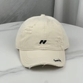 Detailed view of embroidery and distressed holes on this vintage baseball cap - Beige