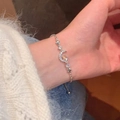 Primer plano de pulsera plateada con dijes de luna y estrella con cristales brillantes - Pulsera Ajustable de Estrella y Luna con Circonita