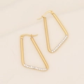 Detail of gold geometric triangle earrings with micro-pave white zircons on beige fabric - Irregular Triangle