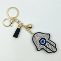 Goldener Hamsa-Hand Schlüsselanhänger mit blauem Auge, schwarzer Quaste und Strass - Schwarz mit Weiß