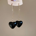 Dettaglio di orecchini a pendente con cuore nero di perle su cartoncino da esposizione - Nero