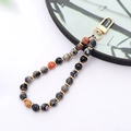 Macro detail of natural stone beads phone strap with polished marble texture and gold accents - K3420 Red Black Fire Agate Natural Stone Pendant