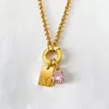 Gold stainless steel necklace featuring a letter M pendant and a sparkling pink rhinestone - M