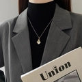 Elegant gold necklace with pearl heart pendant on model in grey blazer and black top - Gold Sector Cat's Eye Stone Necklace