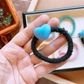Dettaglio dell'elastico per capelli nero con ciondolo a cuore blu floccato - Cuore Blu