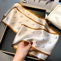 Beige silk scarf with brown equestrian horse pattern shown in smooth soft texture - Small Horse Head