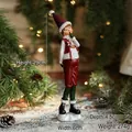 Weihnachtsfigur Junge aus Harz mit roter Paillettenweste und Mütze vor Festtagsdekor - Denkendes Mädchen Ornament