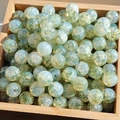 Macro shot of 8-10mm blue and green gold foil glaze glass beads in a wooden tray - 10mm / Enchanting Green