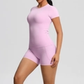 Detail of light purple yoga set showing short sleeve T-shirt and tight shorts on model - Sakura Pink