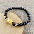 Black obsidian style bead bracelet featuring a gold Pi Xiu charm and golden accents - 6mm Six-Syllable Mantra Pixiu