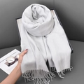 Elegant grey faux cashmere scarf with tassels held against a minimalist home background - 68x180cm / Grey/White