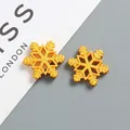 Detail of two 26mm golden snowflake resin charms with frosted texture for DIY crafts - Large (approx 26mm) / Gold