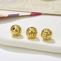 Macro shot of three hollow golden filigree beads for DIY jewelry and bracelets - Style 16