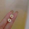 Miniature white and gold daisy stud earrings held by hand to show compact size - Two-tone Daisy Stud
