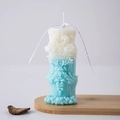 Blue gradient Roman pillar candle with hand-carved floral textures and white ribbon bow - Wave 3 (Blue)