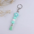 Détail d'un porte-clés fleur en silicone vert menthe avec perles et gland décoratif - Vert Menthe