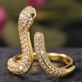 Anillo de serpiente dorado ajustable con circonitas brillantes y ojos de gema azul - Abierto Ajustable / Dorado