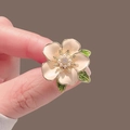 Close-up of luxury enamel camellia brooch with cream petals, pearls and gold finish - X0308 Gardenia