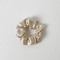Detailed close-up of champagne gold satin scrunchie with soft silk texture and pleats - Without Card / Champagne