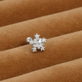 Macro shot of silver snowflake earring featuring claw-set cubic zirconia on a velvet tray - Snowflake Style