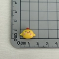 Miniature yellow resin chick charm shown on scale mat for precise size measurement - Yellow Chick