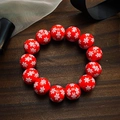 Vue macro de 13 perles en bois rouges avec motifs flocons de neige sur bracelet festif - Flocon de neige