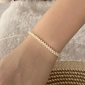 Close-up of bohemian beaded bracelet worn on wrist with casual natural background - Beige