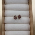Elegant four-prong natural garnet stud earrings with golden finish on cream velvet - Garnet