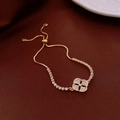 Detalle de pulsera ajustable bañada en oro de 18k con trébol y cristales pavé brillantes - Estilo Trébol de Oro Circón Ajustable