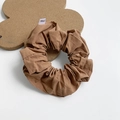 Brown fabric scrunchie with cotton linen texture and small brand label on white surface - Large / Caramel color