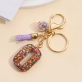 Detail of resin number 0 keychain with colorful sequins, purple tassel and glass ball - Number 0
