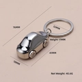 Polished silver F1 racing car metal keychain with dimensions on a pink background - X-016 German Car