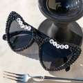 Black heart-shaped bride sunglasses with Wifey beads and pearls on beach background - WIFEY