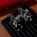 Macro shot of silver metallic flower earrings with abstract flowing petals on a black tray - Silver Abstract Streamline Petal Earrings (S3340)