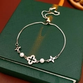 Detalle de pulsera de perlas ajustable con flor de circón y colgante de trébol plata - Pulsera de Perlas de Trébol / Plateado