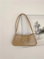 Khaki leather baguette bag with bow detail hanging against a minimalist white wall - Apricot