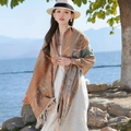 Ethno-Schal in Orange und Grün mit Quasten, getragen von einem Modell am See - Mandarin-Paisley Ethno-Schal