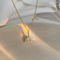Elegant gold fishtail necklace with micro-paved zircons on a ceramic plate - Gold Fishtail Pendant