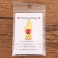 Golden hand shaped Pocket Hug charm with red heart detail on a rustic wooden background - Gold Hand Holding Heart