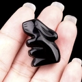 Polished natural black obsidian crystal rabbit figurine held in hand, mini animal carving - Obsidian