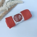Terracotta wrinkle cotton pleated shawl rolled with floral paper band on blue background - Style #22
